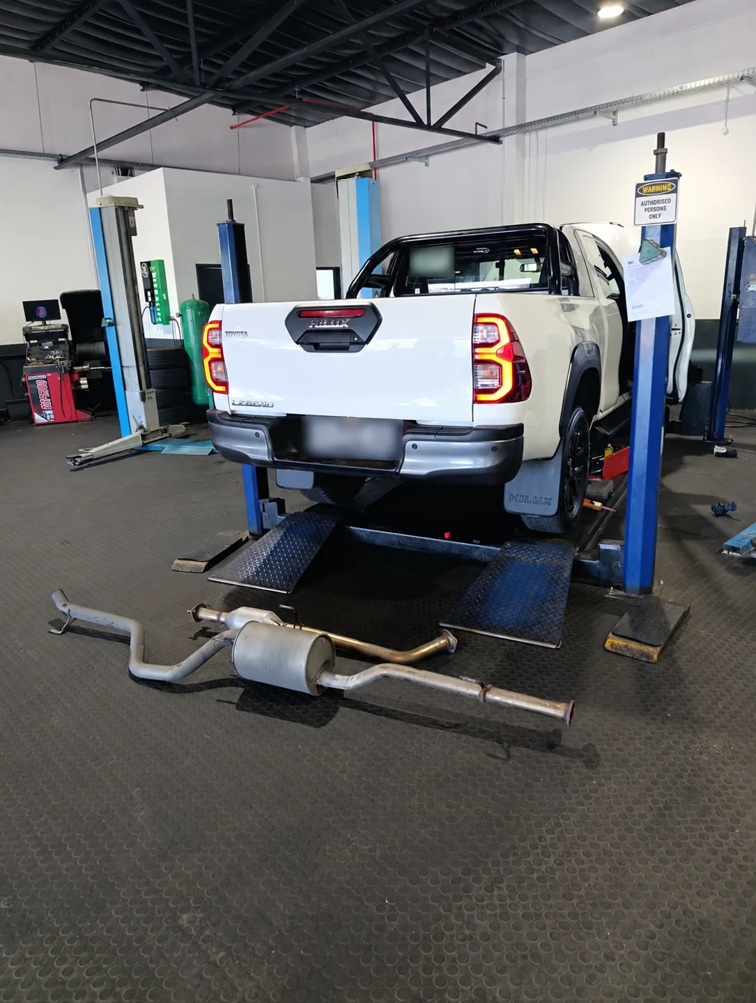 Toyota Hilux on a lift with exhaust components in the Cape Town partner workshop