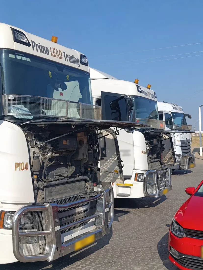 Prime Lead Trading fleet trucks with open engine access panels and plates blurred