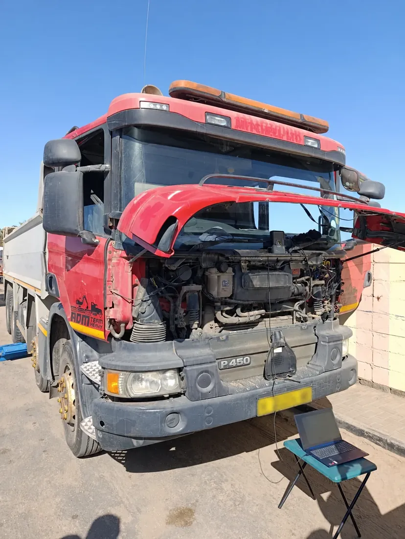 Red Scania P450 with diagnostic equipment and a connected laptop, registration plate blurred
